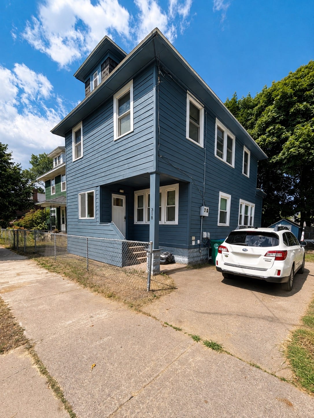 A two-story home finished in new blue lap siding with white window trim